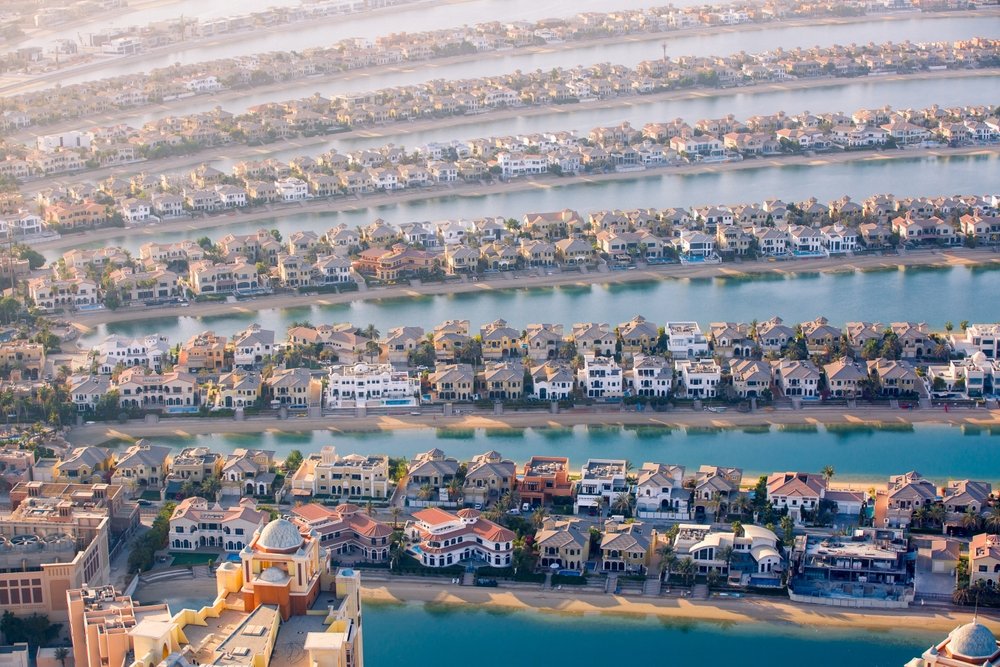 Buyer reviewing a Dubai property purchase cost breakdown with a title deed and calculator on the desk
